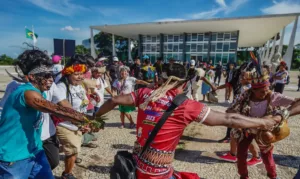 Indígenas reunidos dançando em frente ao Superior Tribunal Federal